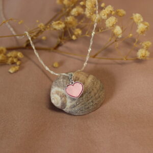 Collar con dije de corazón rosa.